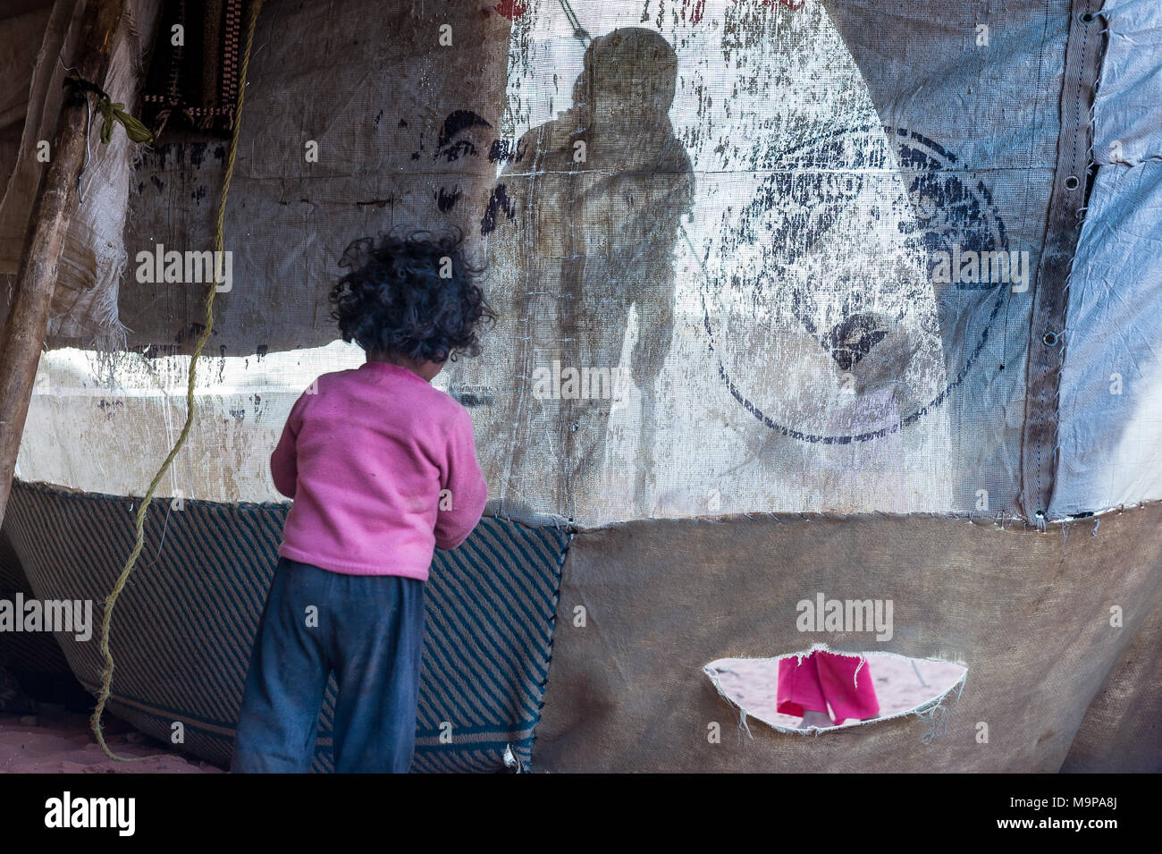 Bedouin Baby spielen und trinken in einem Beduinenzelt in der Nähe von De Grenze von Sausi-Arabia. Stockfoto