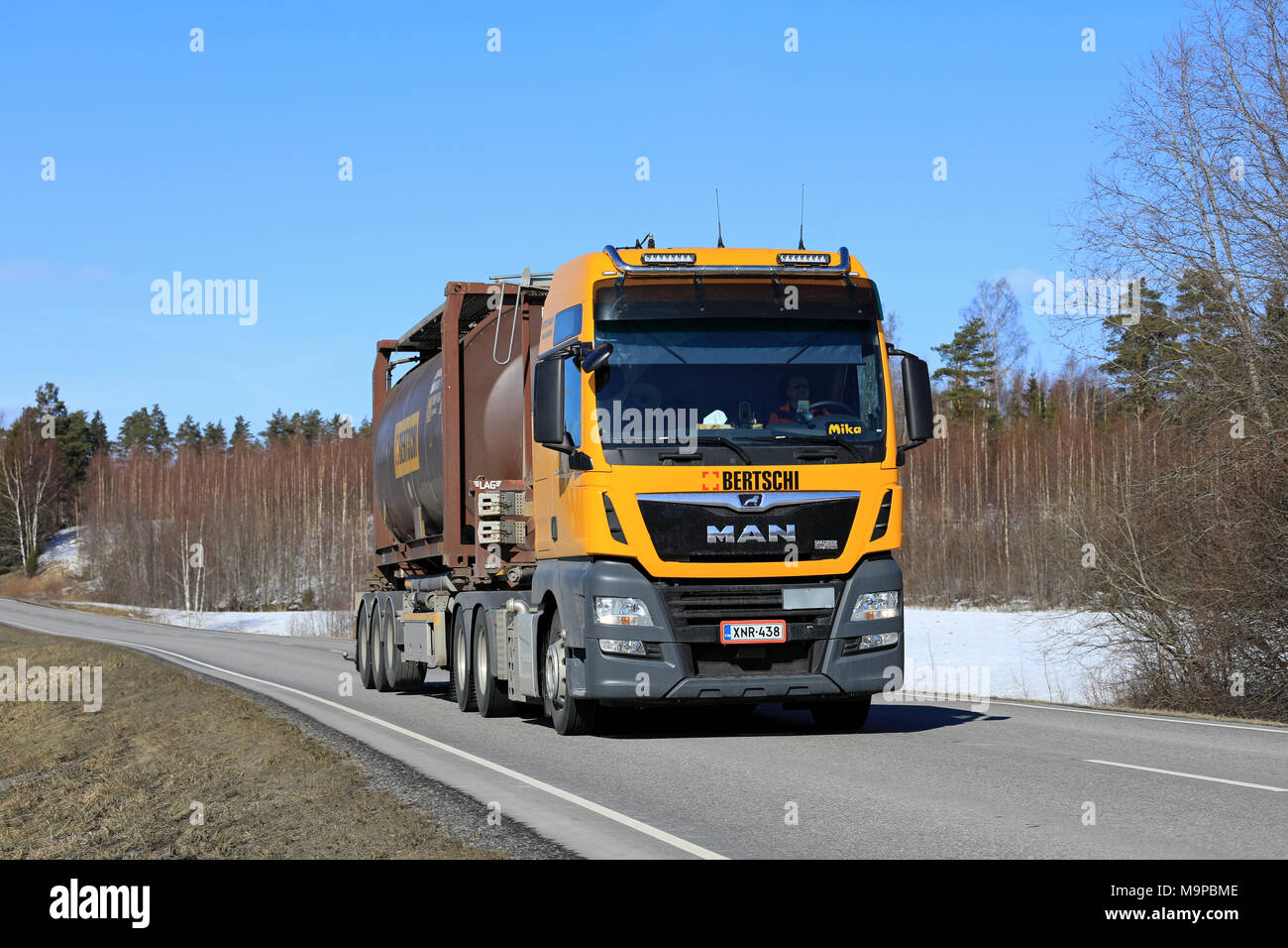 SALO, Finnland - 23. MÄRZ 2018: Gelbe Mann Semi Truck für Bertschi Finland Oy hols Tank Container entlang der Landstraße an einem schönen Frühlingstag. Stockfoto