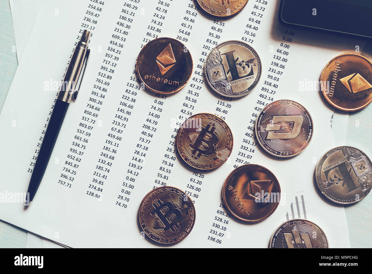 Cryptocurrency Münzen mit Tabelle Wechselkurse, verschiedene crypto Geld auf Schreibtisch Stockfoto