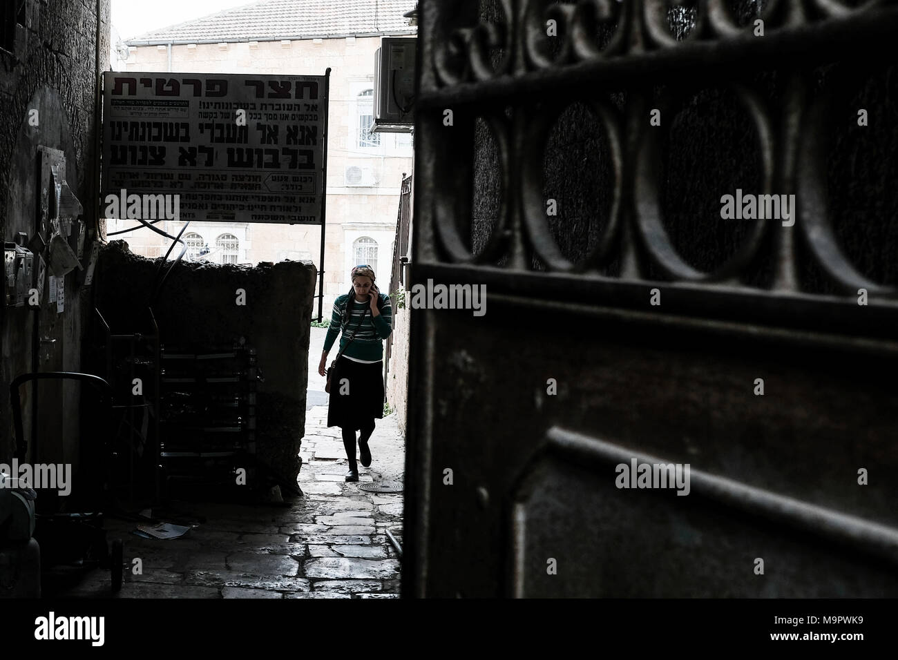 Jerusalem, Israel. 28. März, 2018. Eine Frau betritt eine Gasse in einem Abschnitt des Nachlaot Nachbarschaft in Jerusalem neben einem Schild verbietet der Frauen eintritt, es sei denn bescheiden gekleidet. Credit: Nir Alon/Alamy leben Nachrichten Stockfoto