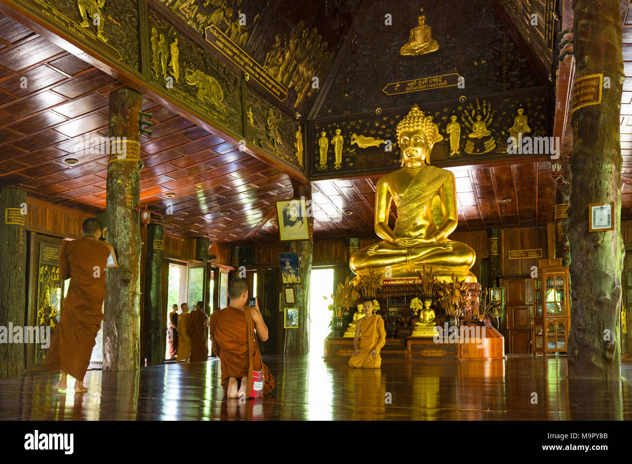 Mönche vor goldenen Buddha, Wat Phra Phuttha "Nimit" Saiyat, Phra Buddha Phukhao, sahatsakhan Bezirk, Kalasin, Isan Stockfoto