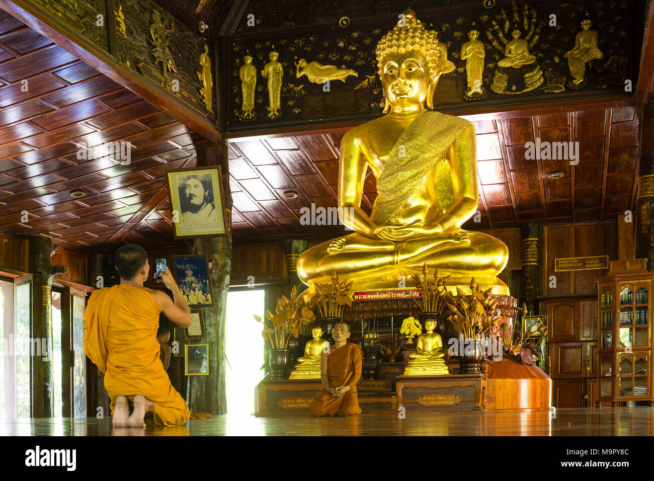 Mönche vor goldenen Buddha, Wat Phra Phuttha "Nimit" Saiyat, Phra Buddha Phukhao, sahatsakhan Bezirk, Kalasin, Isan Stockfoto