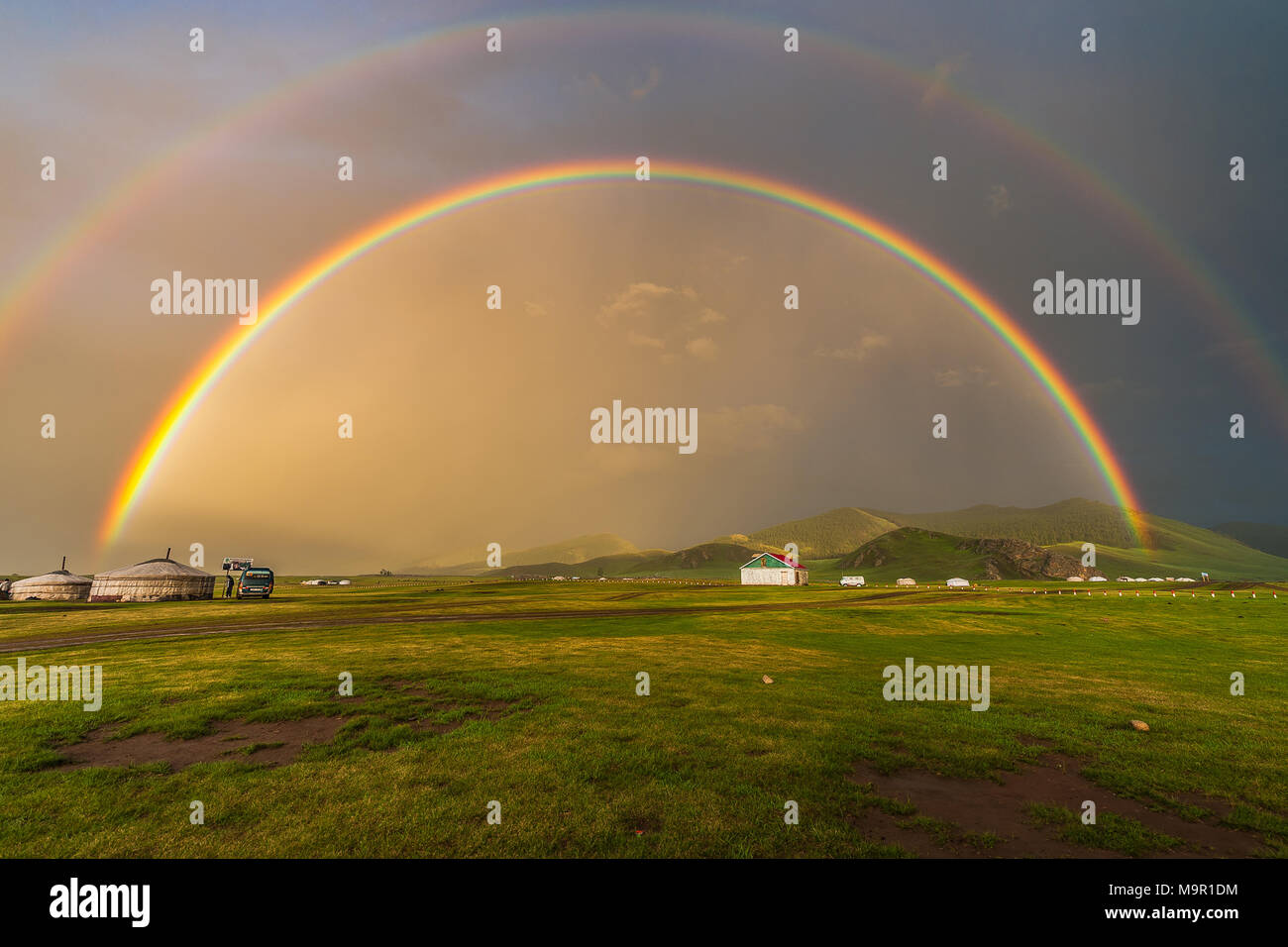 Doppelter Regenbogen über Nomad Jurten in eine grüne Landschaft, Mongolei Stockfoto