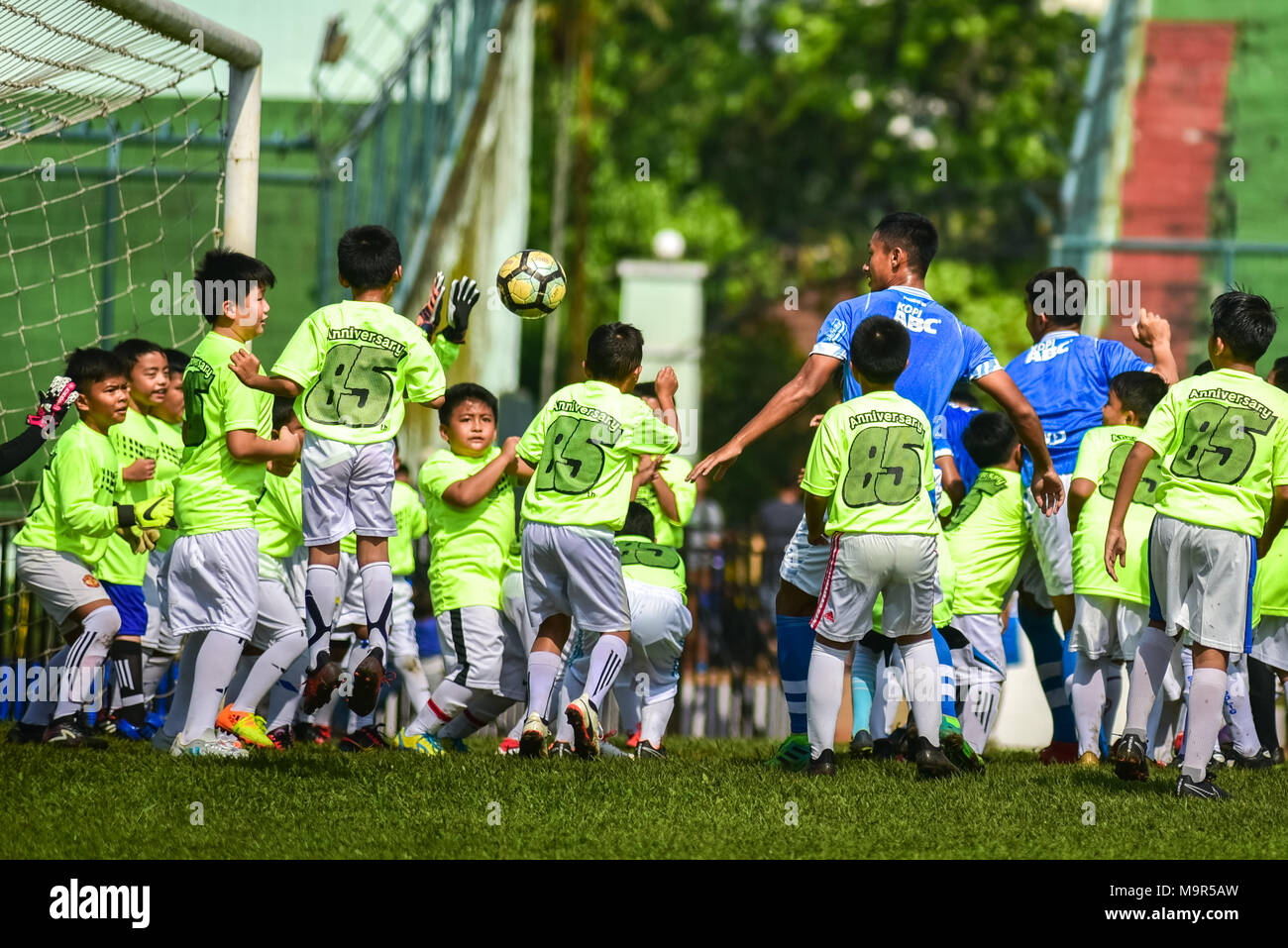 Fünf Spieler der Indonesischen Fußball Club der Persib Bandung spielen gegen 85 Kinder in einer Ausstellung mit seinen 85. Jahrestag zu feiern. Stockfoto