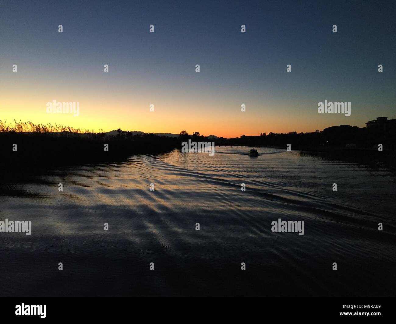 Fußspuren im Sand bei Sonnenuntergang. Schönen tropischen Sandstrand mit Wellen des Meeres. Spuren am Ufer. Stockfoto