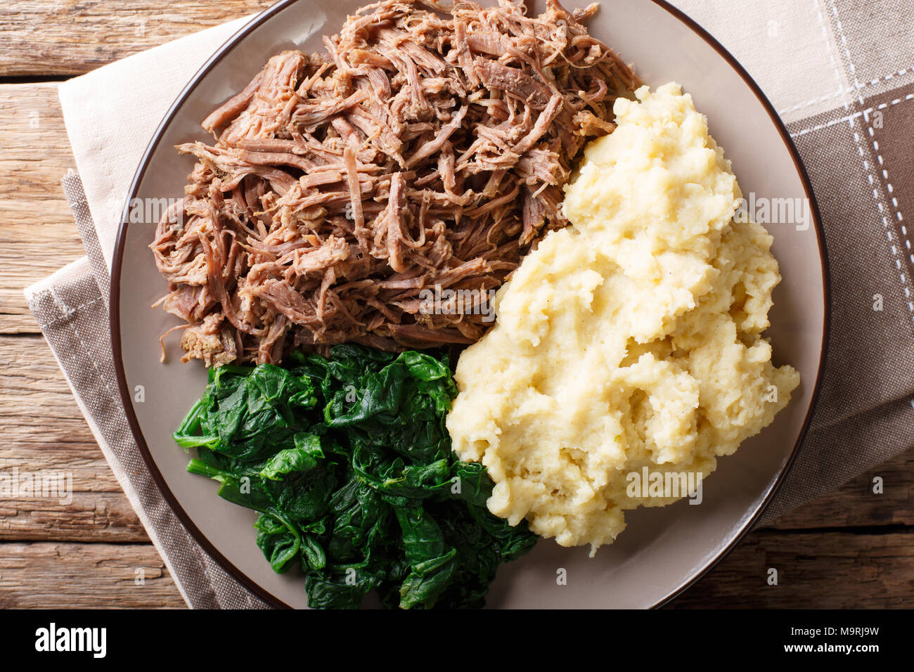 Südafrikanisches Essen: - Seswaa Shredded Beef mit sadza Porridge und Spinat close-up auf einem Teller auf den Tisch. horizontal oben Ansicht von oben Stockfoto