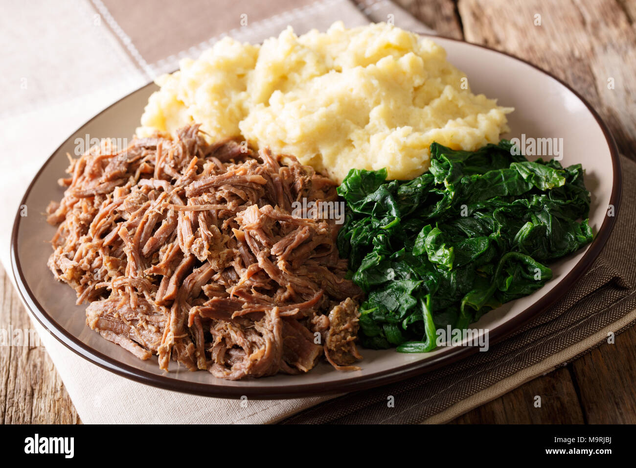 Südafrikanisches Essen: - Seswaa Shredded Beef mit sadza Porridge und Spinat close-up auf einem Teller auf den Tisch. Horizontale Stockfoto