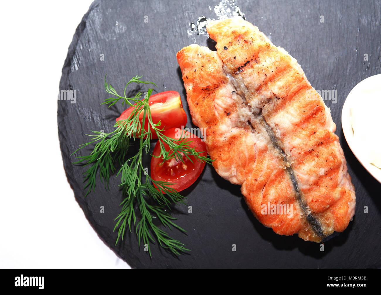 Mit gegrilltem Fisch und Gemüse auf dunklen Holzplatte Platte Stockfoto