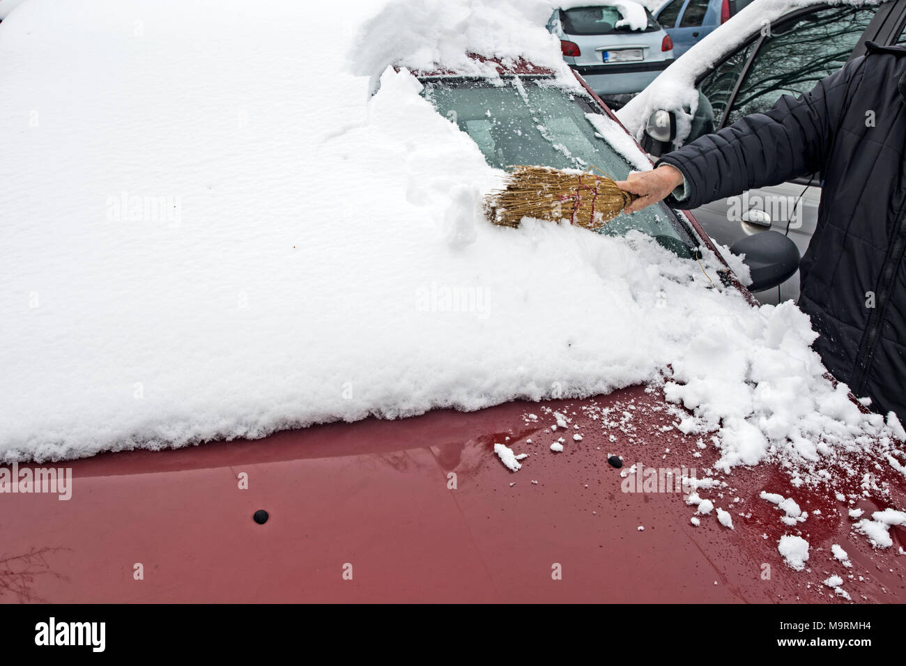 Mit einer Bürste Schnee aus dem Auto entfernen Stockfotografie - Alamy