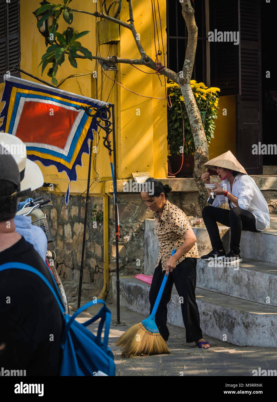 Vietnamesische Dame Essen auf der Straße in Hoi An, Vietnam Stockfoto