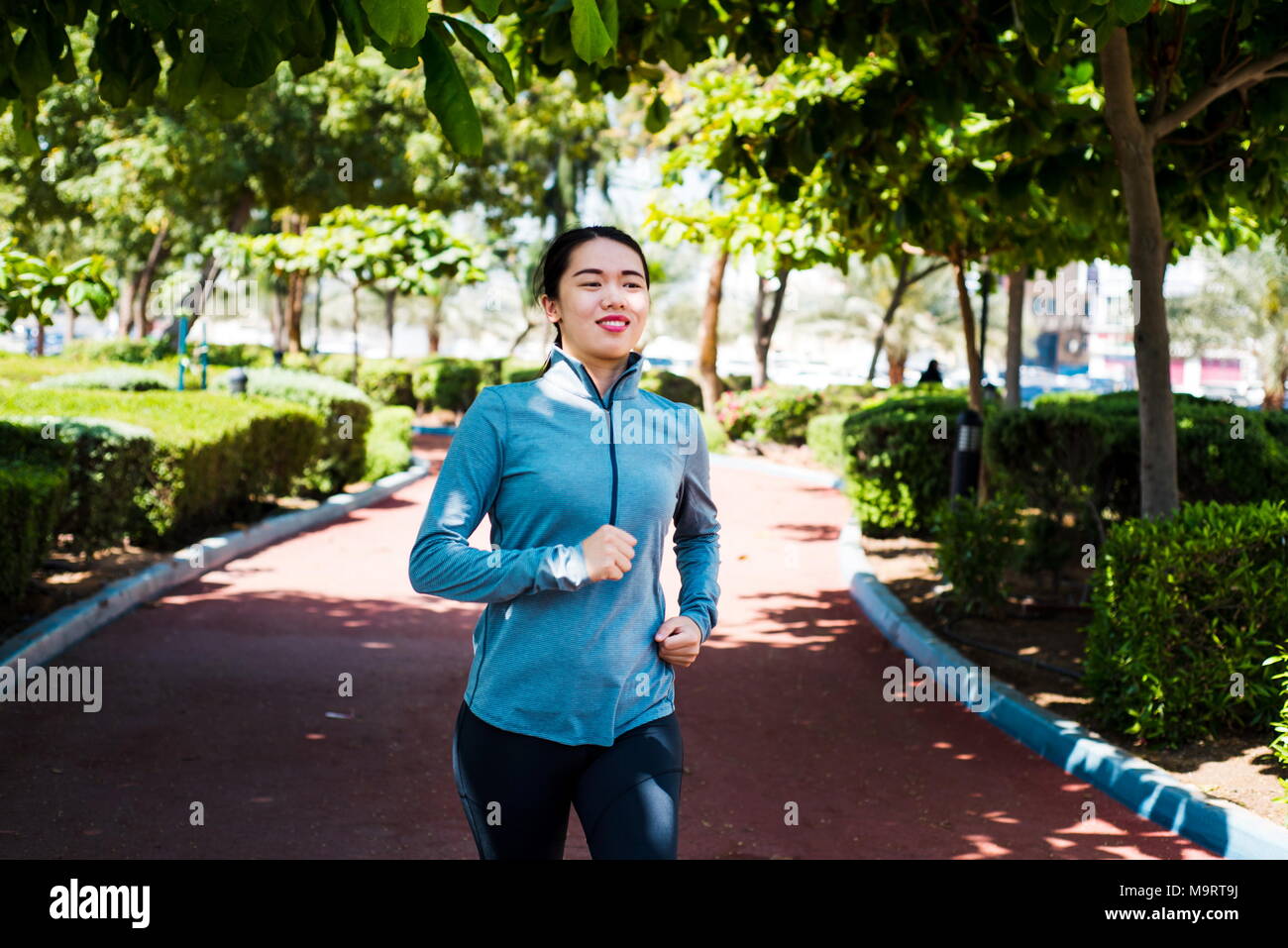 Happy girl Joggen auf der Laufstrecke im Park Stockfoto