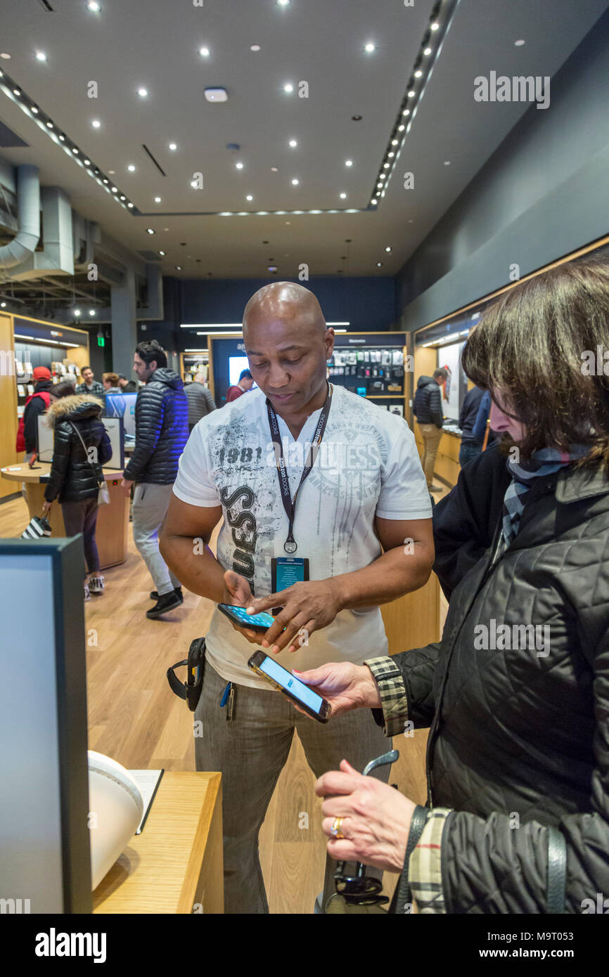 Washington, DC - Amazon's Buchhandlung in Washingtons Stadtteil Georgetown. Assistant Store Manager John Kürzere zeigt Kunden, wie ein Buch zu prüfen." Stockfoto