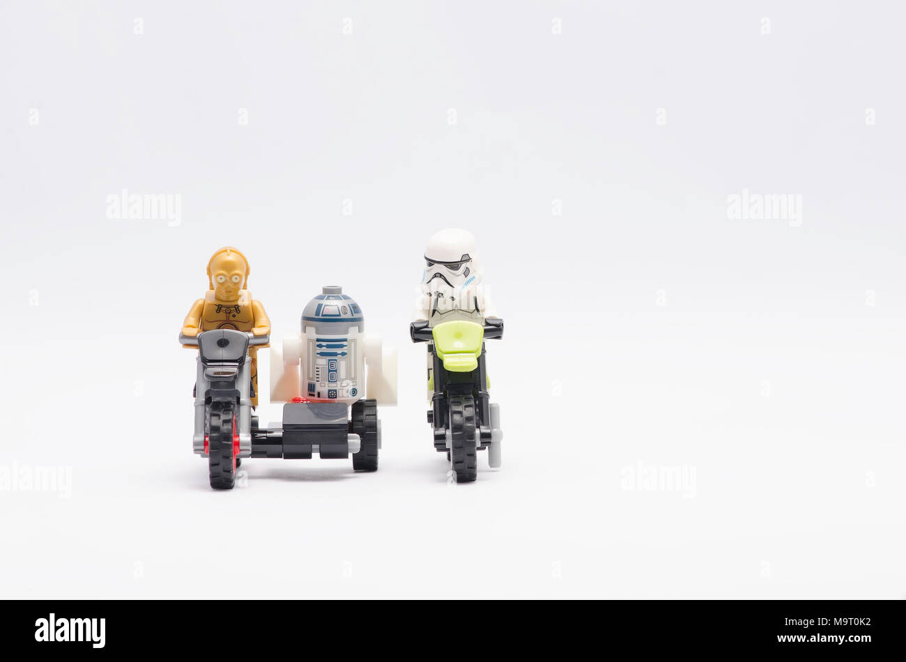 Lego c3po und r2d2 reiten Motorrad mit stormtrooper auf weißem Hintergrund. Stockfoto