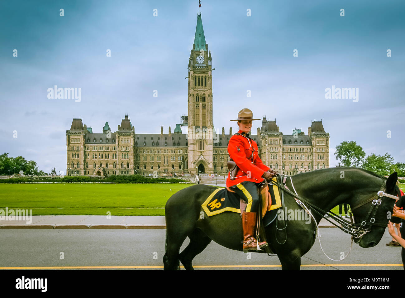 Weibliche Mountie in Rot zeremoniellen Einheitliche zu Pferd mit dem Parliament Hill oder Peace Tower im Hintergrund, Ottawa, Kanada Stockfoto