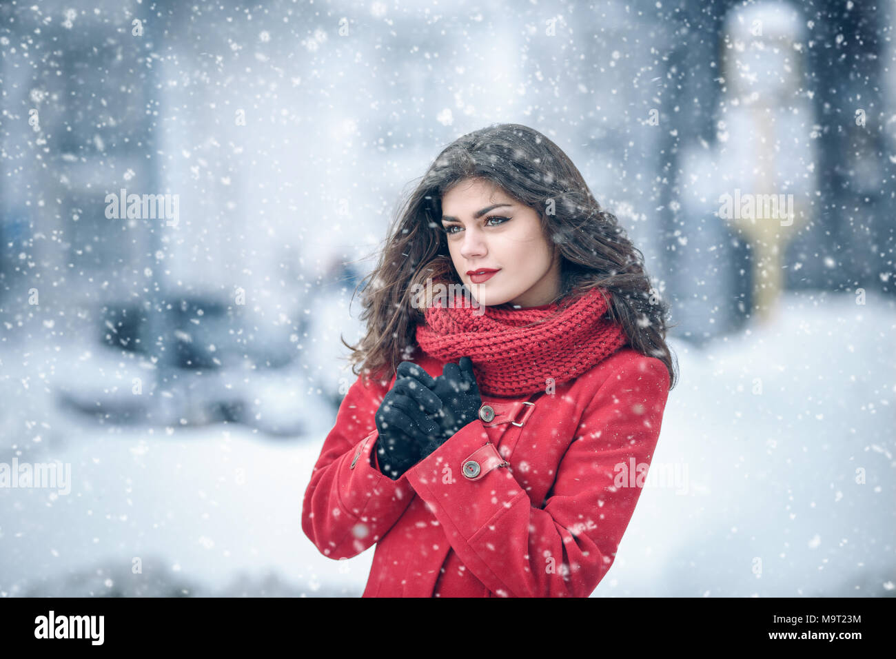 Winter. Mädchen brunette capless Lächeln auf dem Hintergrund der Schnee. Close-up. Haar entwickelt. Wind und Schnee Stockfoto