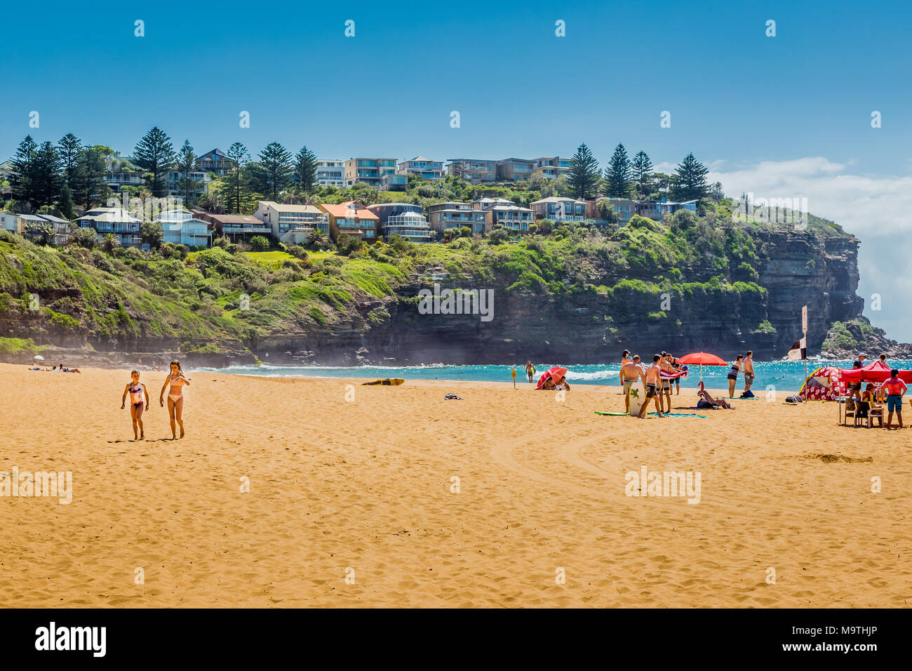 Blick auf bilgola Strand, mit der landspitze im Hintergrund, und die Menschen genießen den Sonnenschein. Stockfoto