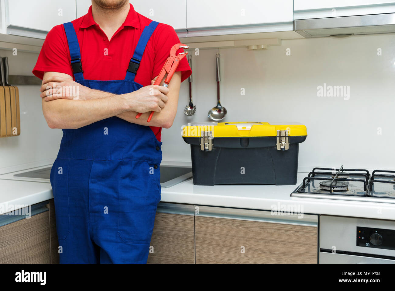 Klempner mit Schlüssel in der Hand in der heimischen Küche Stockfoto