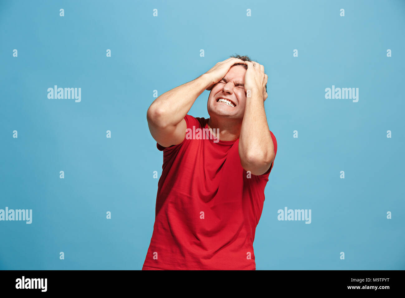 Schöner Mann im Stress isoliert auf Blau Stockfoto