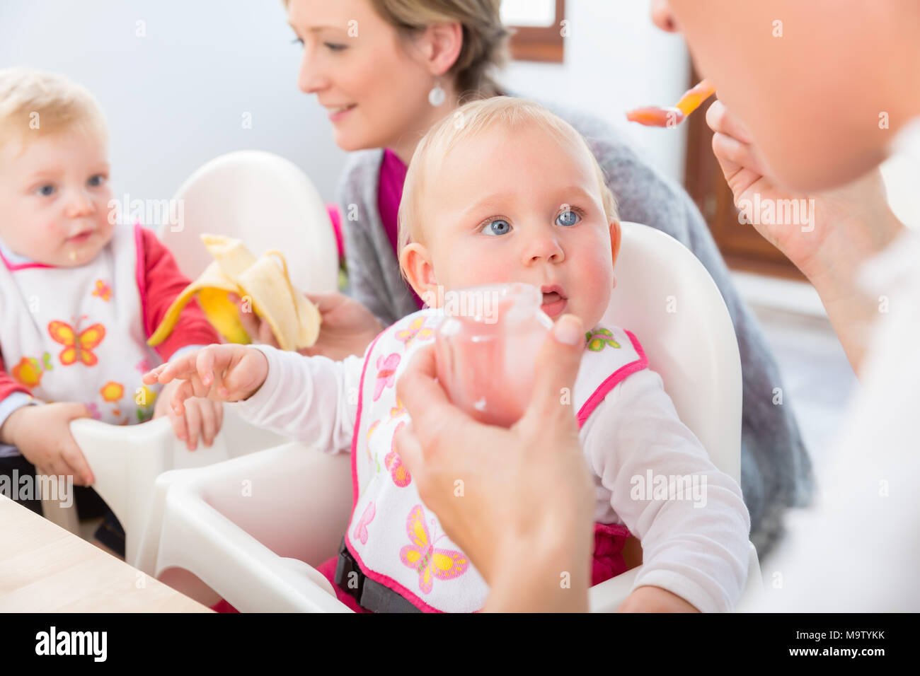 Porträt eines süßen und gesunden Baby Mädchen mit blauen Augen Blick auf ihre Mutter Stockfoto