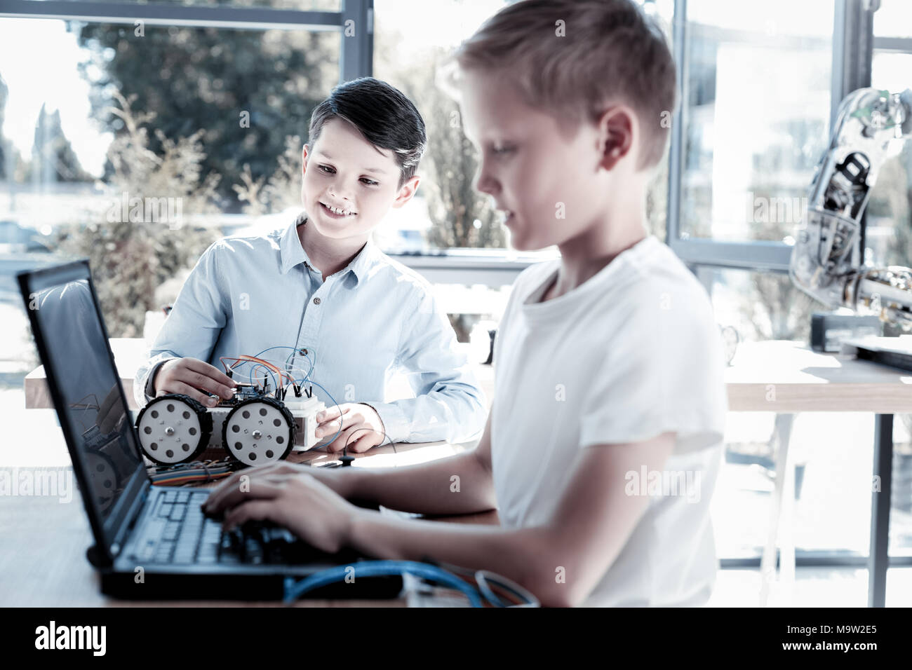 Die besten Freunde an neuen Roboter- Fahrzeug mit Laptop Stockfoto