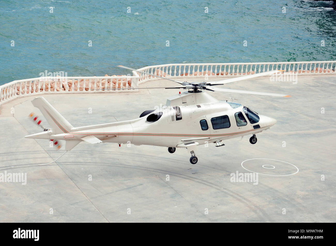 Helikopter fliegt über dem azurblauen Meer Stockfoto