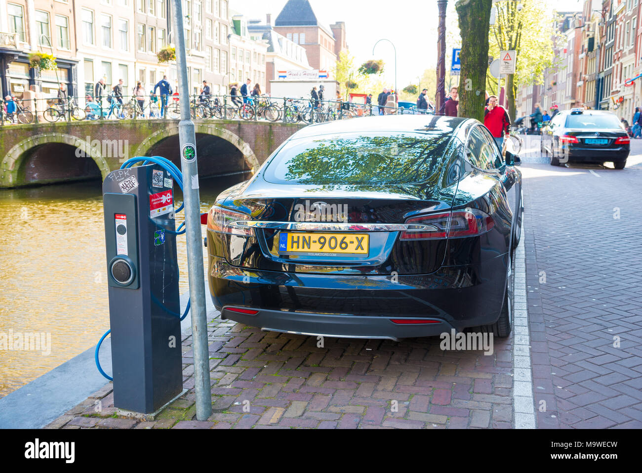 Amsterdam, Niederlande - 19 April, 2017: ein Tesla Model S Elektroauto Aufladen an eine Ladestation auf der Straße von einer Gracht in Amsterdam. Stockfoto