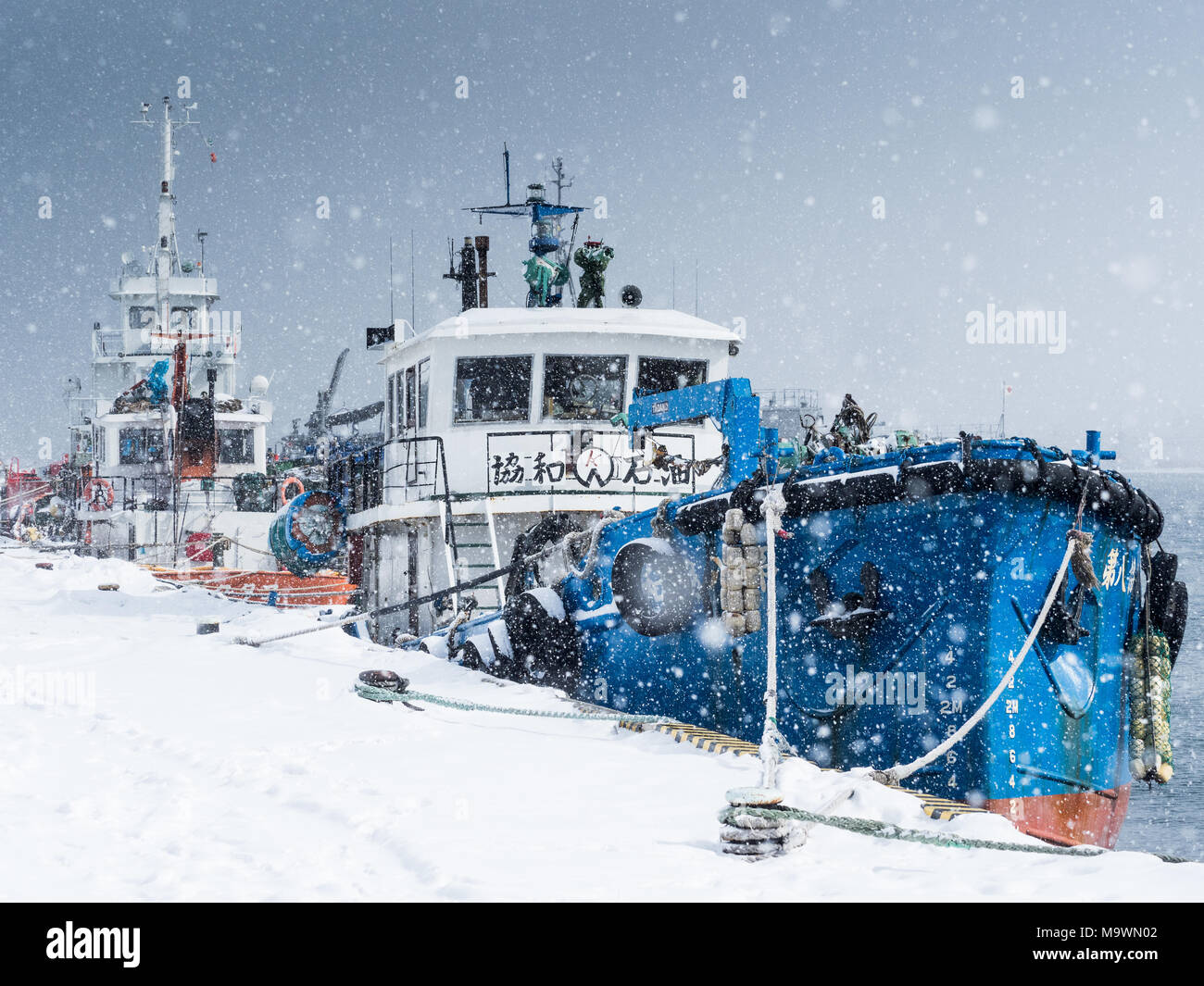 Hakodate Japan - Japan im Winter. Boote, die während eines Winterschneesturms am Hafen in Hakodate auf der nordjapanischen Insel Hokkaido gefesselt waren. Stockfoto