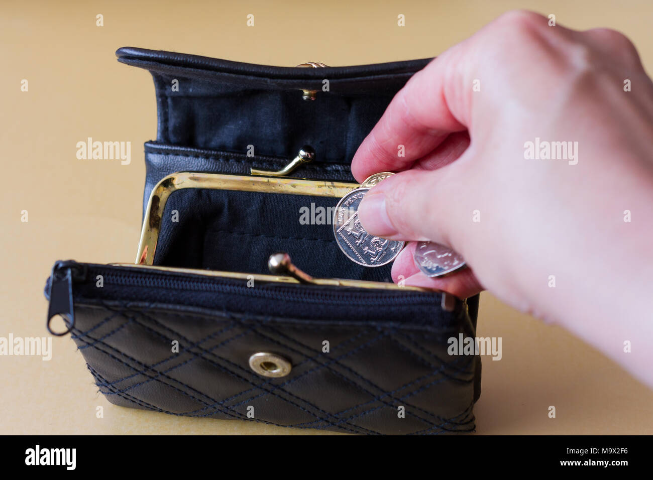 Weibliche Hand einige Münzen in den Geldbeutel Stockfoto