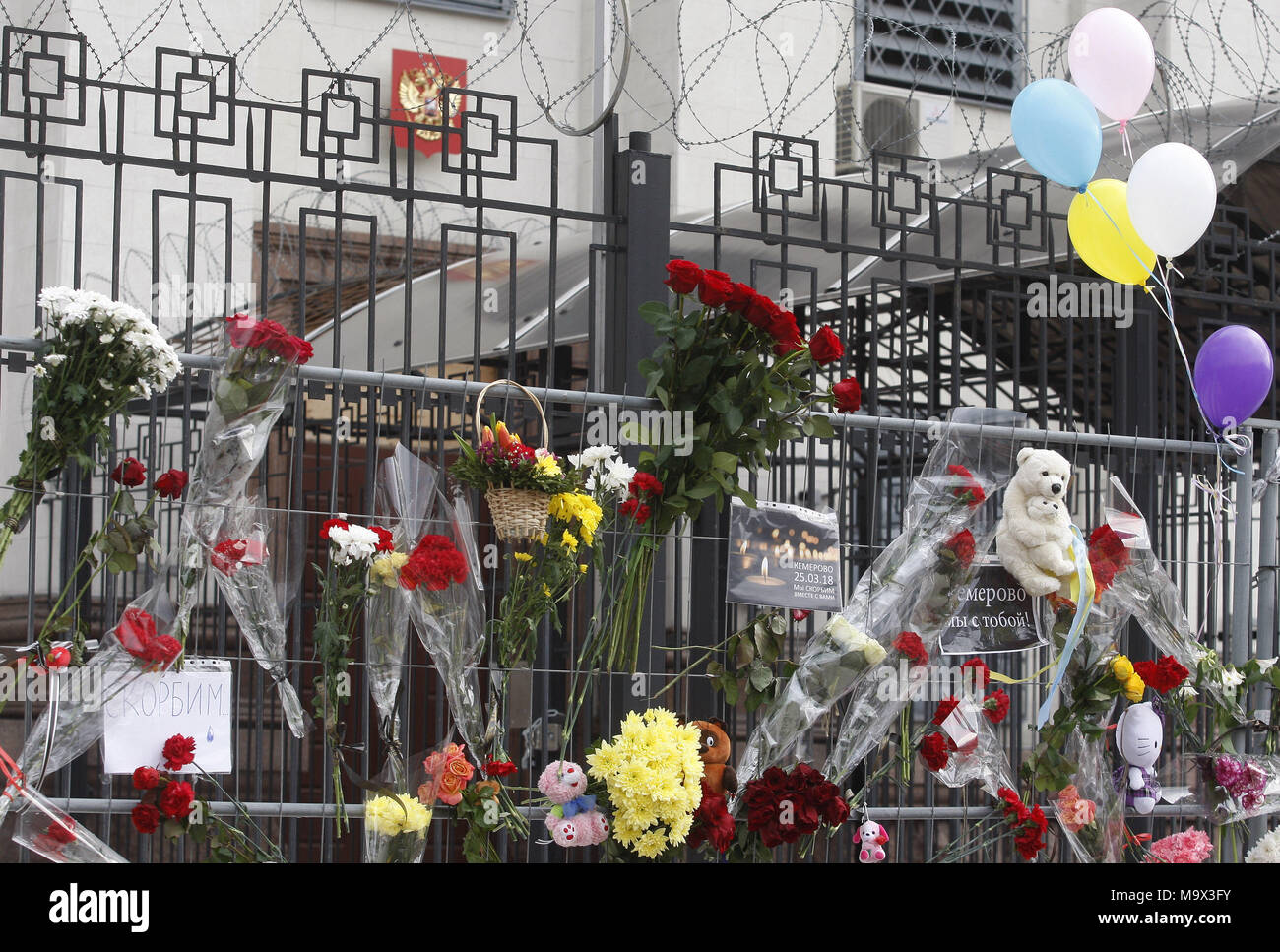 Kiew, Ukraine. 28. März, 2018. Blumen und Spielzeug im Gedenken für die Opfer des Feuers im Einkaufszentrum "Zimnyaya Vishnya" in der westsibirischen Stadt Kemerowo, sind vor der russischen Botschaft in Kiew, Ukraine, am 28. März 2018 gesehen. Berichten zufolge mindestens 64 Menschen, darunter 41 Kinder, in den tödlichen Vorfall am 25. März verstorben. Credit: Serg Glovny/ZUMA Draht/Alamy leben Nachrichten Stockfoto