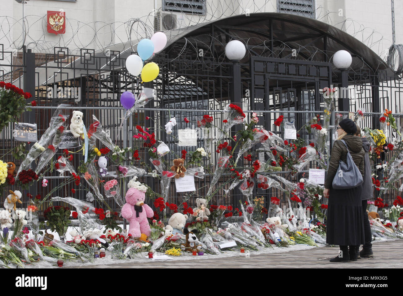 Kiew, Ukraine. 28. März, 2018. Die ukrainer Blumen und Spielzeug im Gedenken für die Opfer des Feuers im Einkaufszentrum "Zimnyaya Vishnya" in der westsibirischen Stadt Kemerowo, vor der russischen Botschaft in Kiew, Ukraine, am 28. März 2018. Berichten zufolge mindestens 64 Menschen, darunter 41 Kinder, in den tödlichen Vorfall am 25. März verstorben. Credit: Serg Glovny/ZUMA Draht/Alamy leben Nachrichten Stockfoto