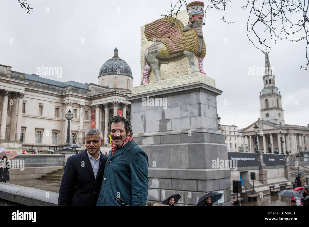 (180328) - LONDON, 28. März 2018 (Xinhua) - Michael Rakowitz (R) wirft mit Sadiq Khan, Bürgermeister von London, nach seiner neuen Arbeit "Die unsichtbaren Feind sollte nicht vorhanden' ist auf den vierten Sockel im Londoner Trafalgar Square, Großbritannien enthüllt wurde, am 28. März 2018. Die Skulptur aus 10.500 leeren Irakischen Datum Sirup Dosen, ist eine Nachbildung der Lamassu, eine geflügelte Stier und schützende Gottheit, die am Eingang des Nergal Tor von Ninive ab 700 v. Chr. stand, bis er von ISIS im Jahr 2015 zerstört wurde. Es ist der 12. die Arbeit an der vierten Sockel zu erscheinen seit der Inbetriebnahme im Jahre 1998 begann, und wird o Stockfoto