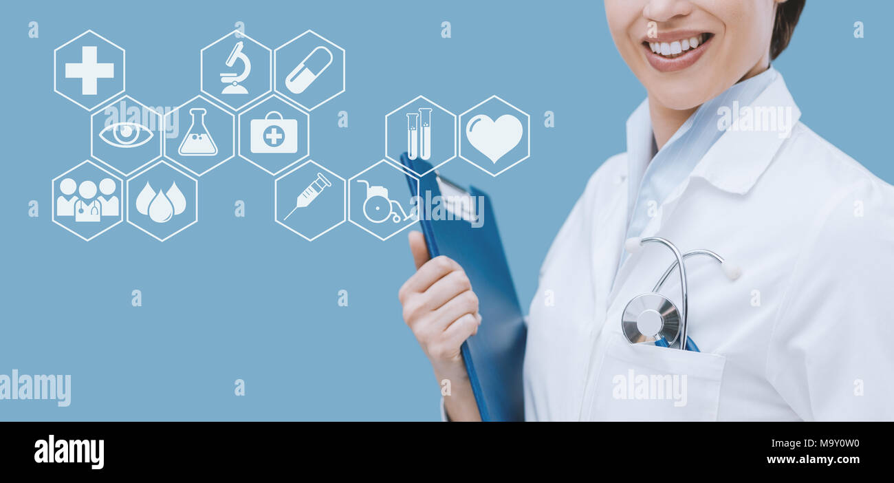 Lächelnd weibliche Arzt Holding ein Clipboard und posieren, Healthcare Professionals Stockfoto