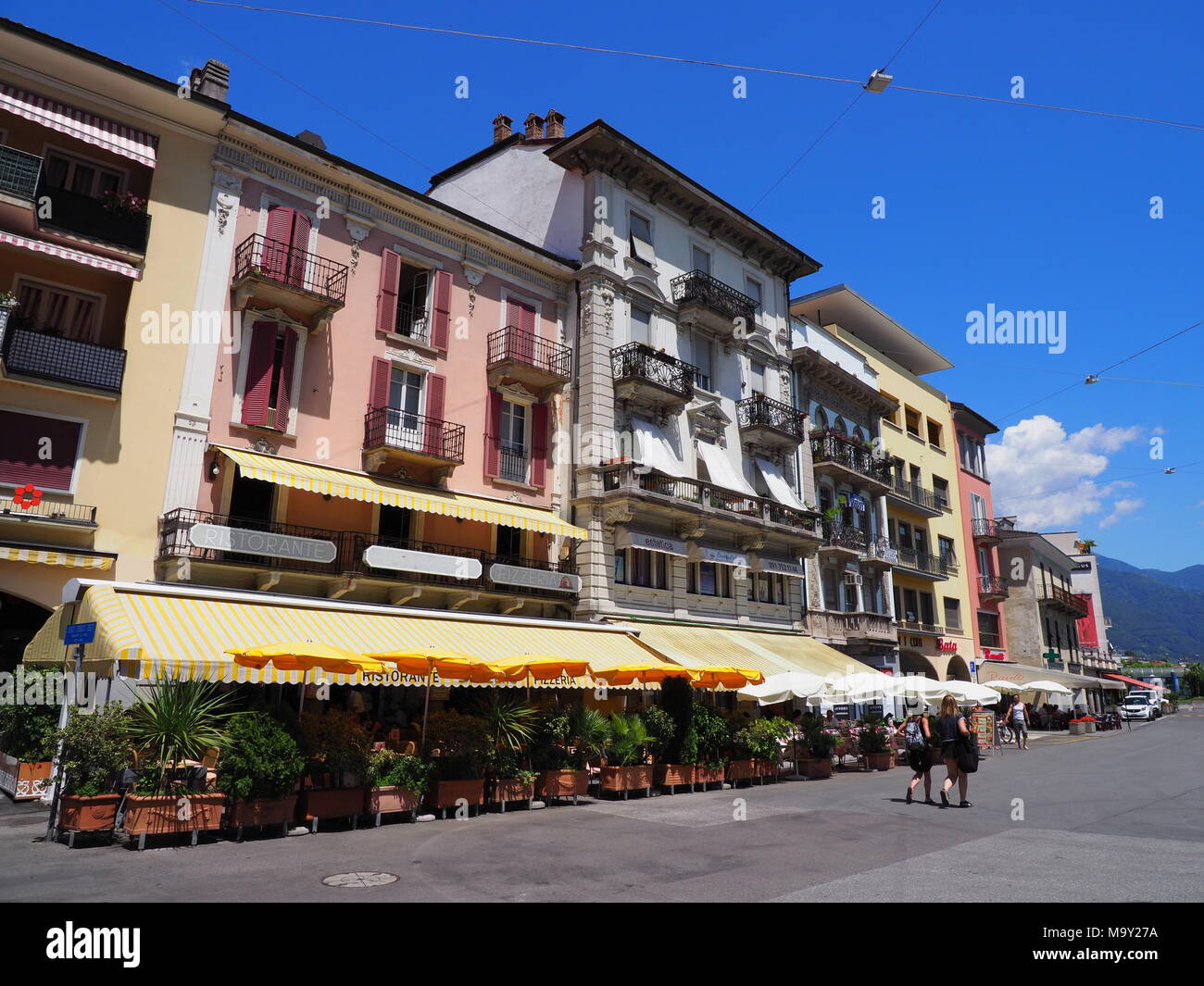 Farbige Gebäude auf der Piazza Grande in Locarno Main City Square in der Schweiz mit Bars, Restaurants, Straßenbahn fahren Stockfoto