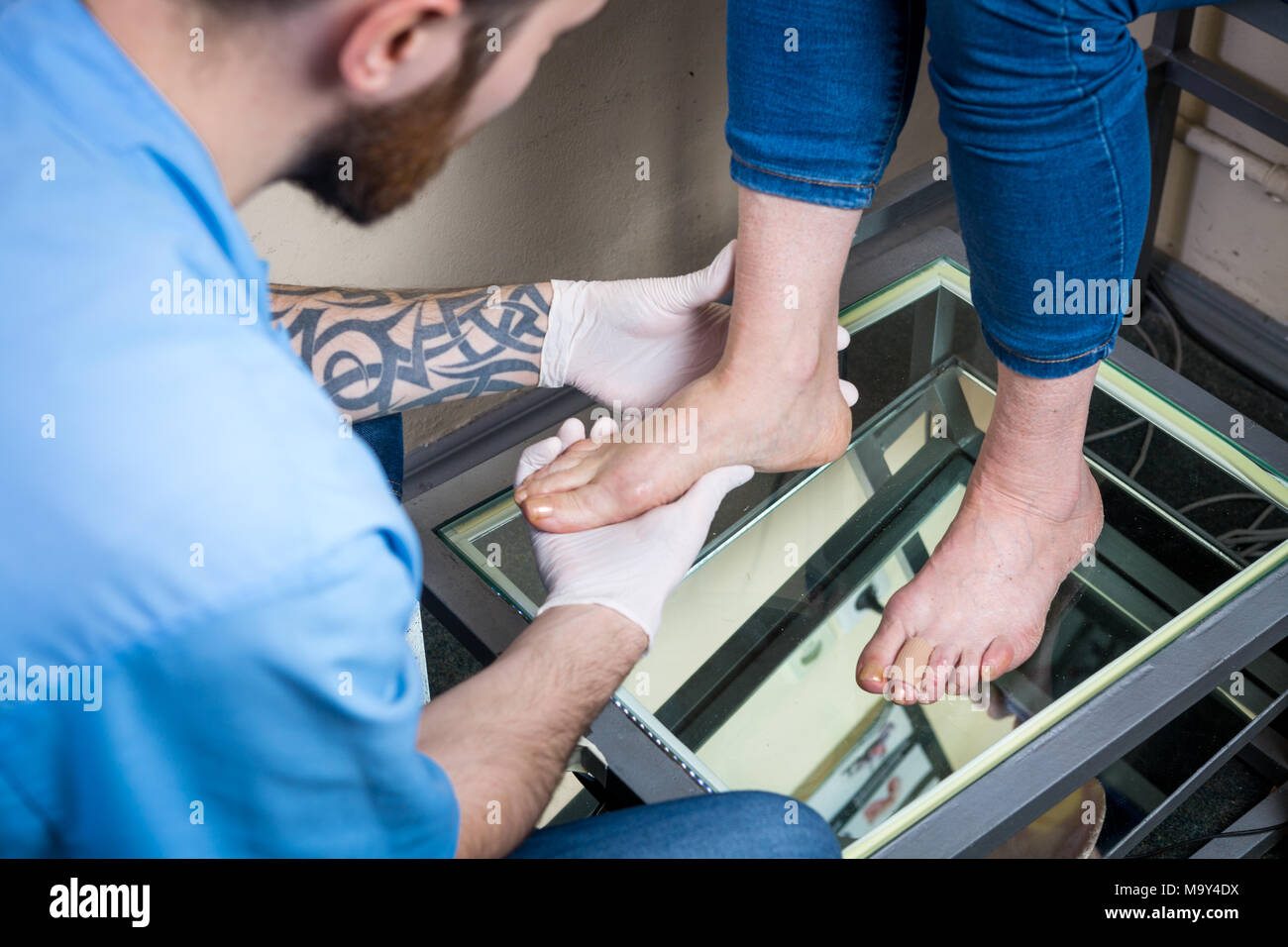 Die hände eines jungen Mannes Arzt Orthopäde führt Diagnose, Fuß Fuß Test einer Frau, die für die Herstellung von individuellen, orthopädische Einlagen. Stockfoto