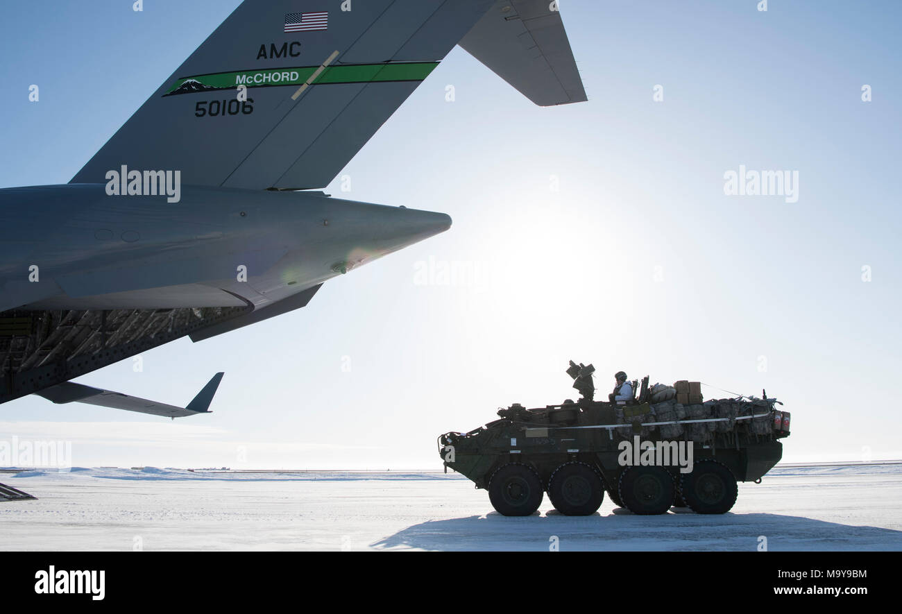 Ein Soldat der US-Armee treibt einen Interim gepanzertes Fahrzeug Stryker auf eine C-17 Globemaster III während der Übung Arktis Pegasus bei Deadhorse, Alaska, 13. März 2018. Die Flieger auf der 62. Airlift Wing zugeordnet flogen zwei C-17 Globemaster III zu Soldaten und vier Strykers liefern für die Übung zu Deadhorse. (U.S. Air Force Foto von älteren Flieger Tryphäna Mayhugh) Stockfoto