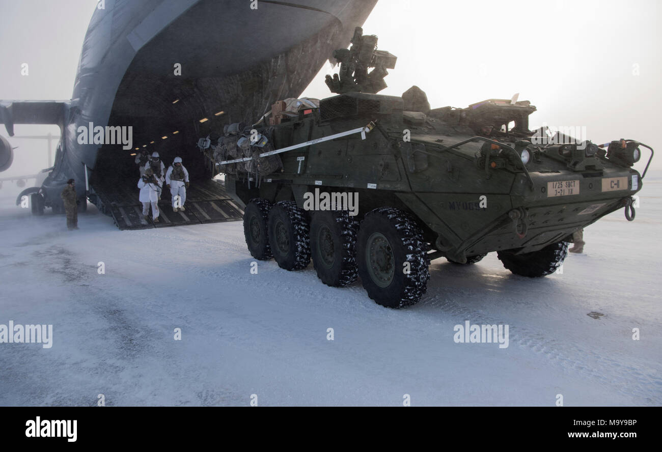 Us-Soldaten und einer Interimsüberprüfung gepanzertes Fahrzeug Stryker Verlassen einer C-17 Globemaster III während der Übung Arktis Pegasus bei Deadhorse, Alaska, 13. März 2018. Die Ausübung getestet, der Luftwaffe und der Armee Fähigkeit in kaltem Wetter zu betreiben. (U.S. Air Force Foto von älteren Flieger Tryphäna Mayhugh) Stockfoto