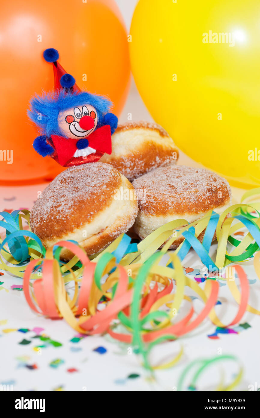 Krapfen oder Krapfen mit Clowns, Luftschlangen und Ballons Stockfoto