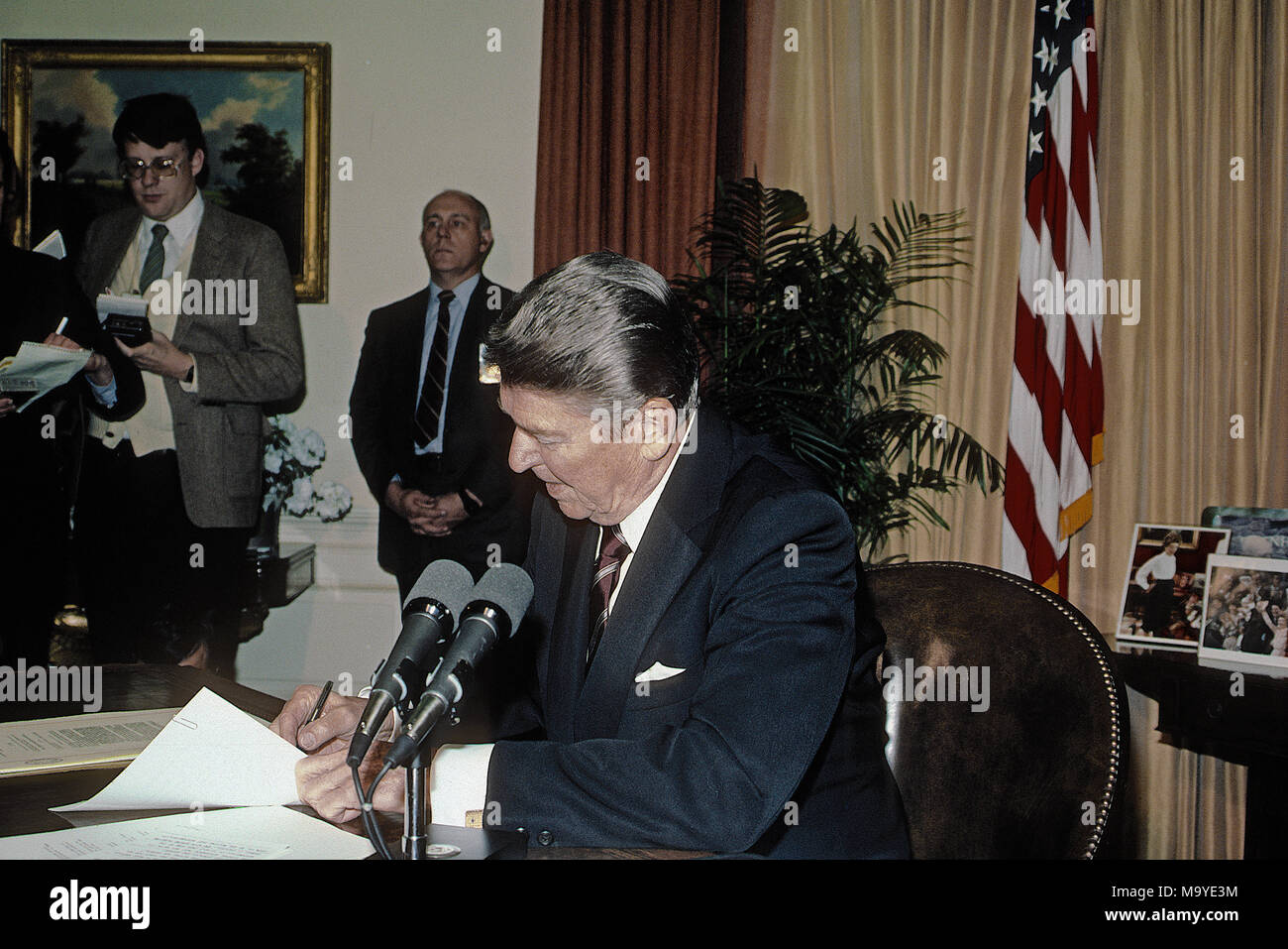 Washington DC., USA, 6. März 1985 Präsident Ronald Reagan an seinem Schreibtisch im Oval Office des Weißen Hauses sitzt, die Unterzeichnung der Veto Nachricht für die Farm Credit und Afrikanischen Hungerkatastrophe Bill Credit: Mark Reinstein/MediaPunch Stockfoto