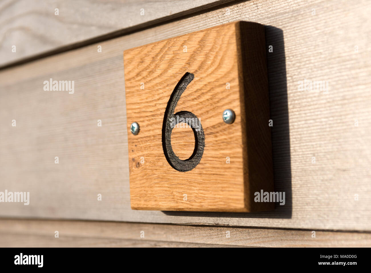 Die Zahl sechs geschnitzte in ein Holz Fliese Plakette auf ein Zuhause zu zeigen die Eigenschaften Adresse Stockfoto