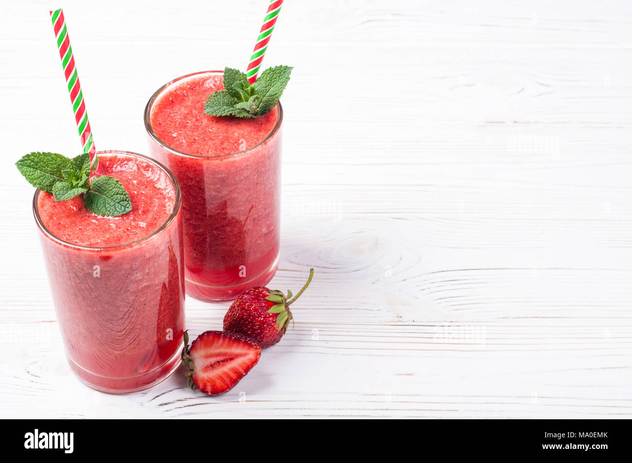 Strawberry Smoothie oder Milchshake in Glas auf weißem Hintergrund. Gesunde Lebensmittel für Frühstück und Snacks. Diät und detox Konzept. Ansicht von oben Stockfoto