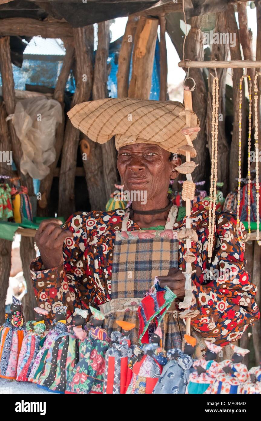 Herero Frau in traditionellen deutschen kolonialen Kleid und Kuh - Horn hat vor Ihr Souvenir dolls Stall, Namibia Afrika. Stockfoto