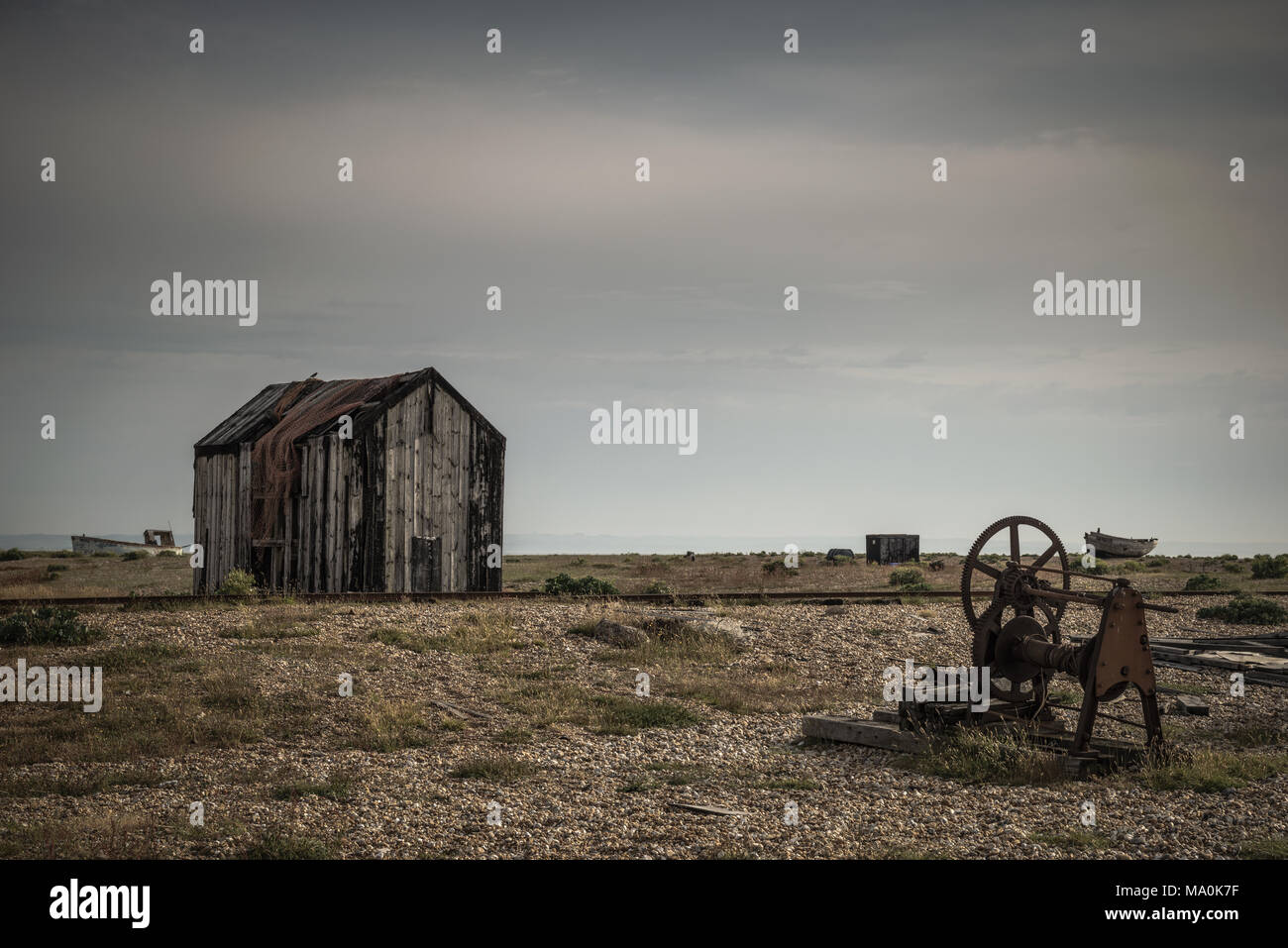 Eine verrostete alte Stück von Maschinen in der Nähe eines alten, verlassenen Hütte auf der Kiesstrand in Dungeness in Kent Stockfoto