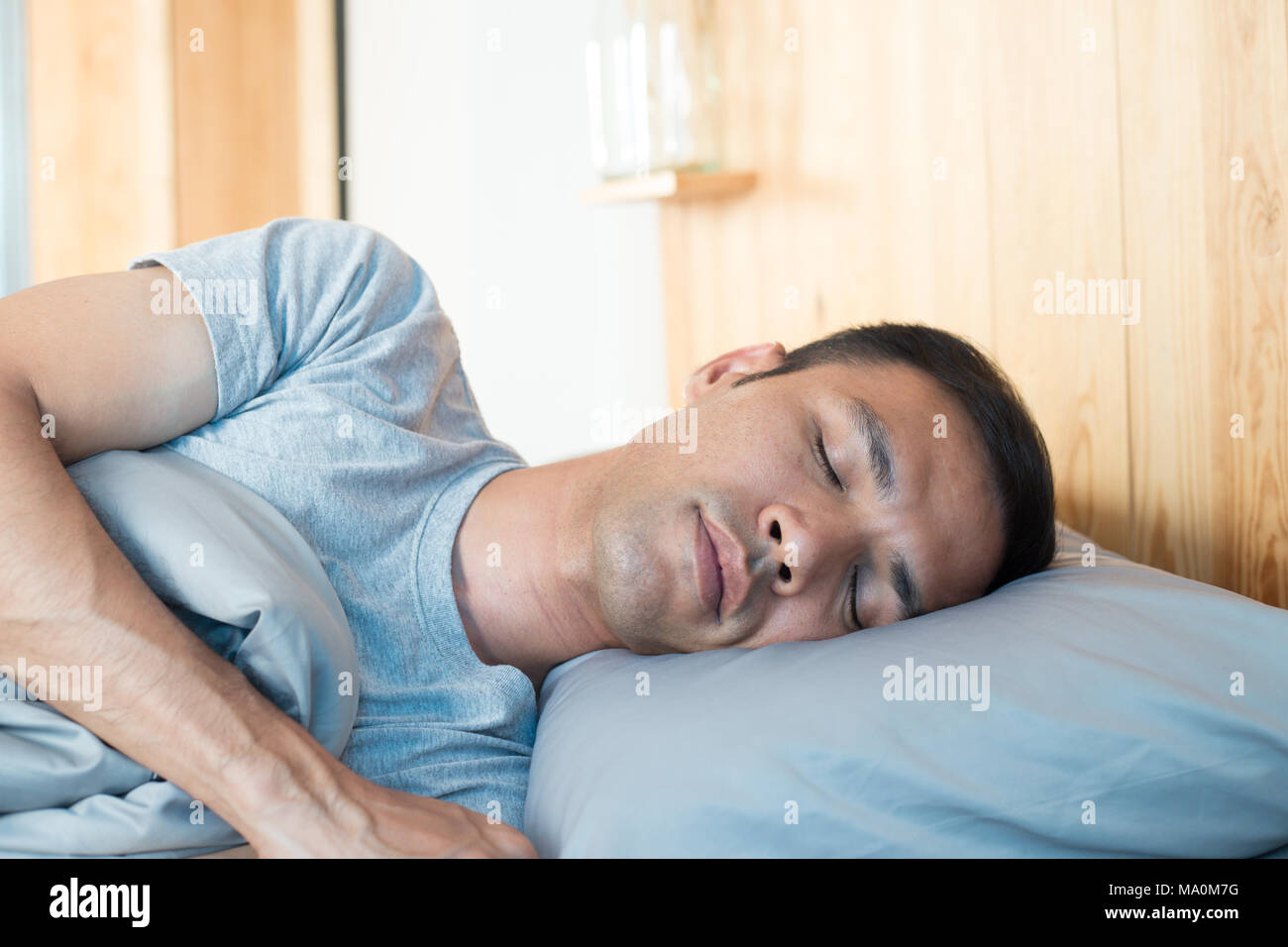 Asiatischer Mann schlafend auf dem Bett in seinem Zimmer und Glücklichkeit schlafen Stockfoto