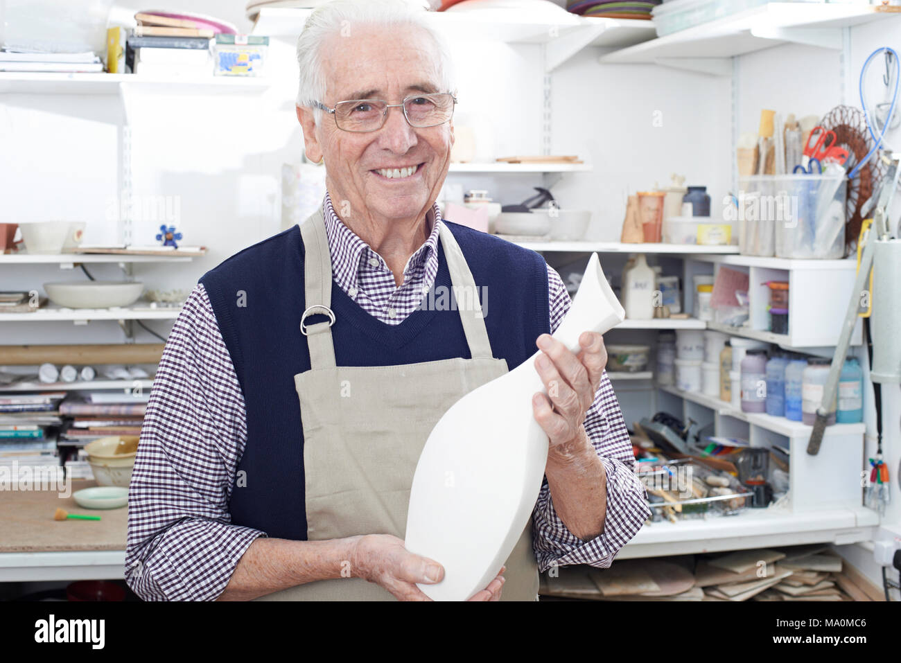 Portrait Of Senior Man Holding Vase aus Keramik Studio Stockfoto