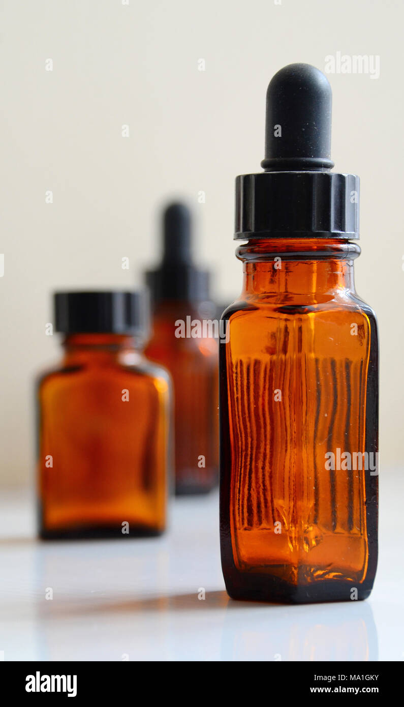 Verschiedene Größen von Braun/Gelb Arzneimittel, Flaschen, darunter auch einige mit Pipetten. Stockfoto