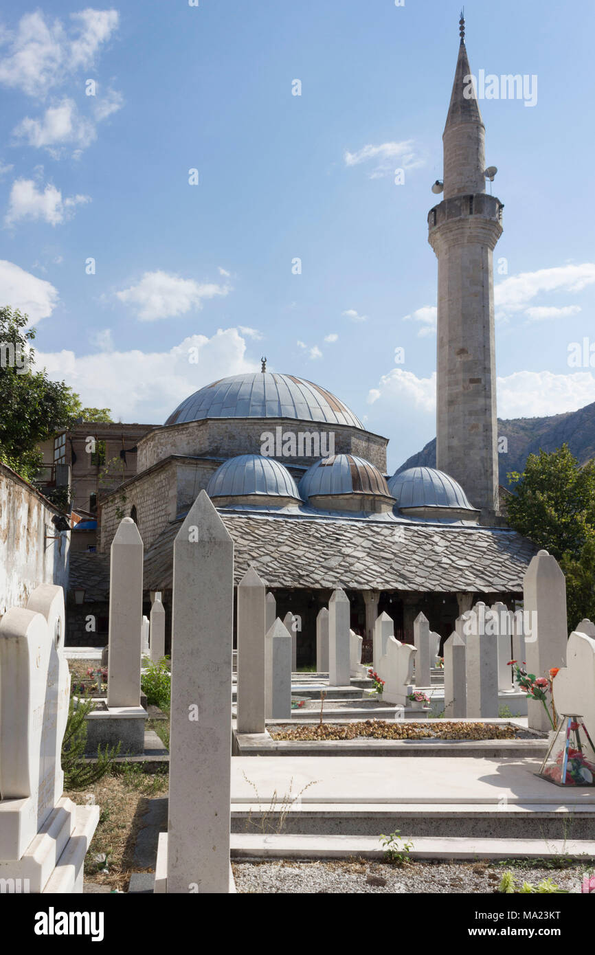 MOSTAR, BOSNIEN UND HERZEGOWINA - 17. AUGUST 2017: Architektonische Blick auf Nesuh Aga Vucjakovic Moschee, rurrounded durch Gräber von Menschen, die während der w getötet Stockfoto