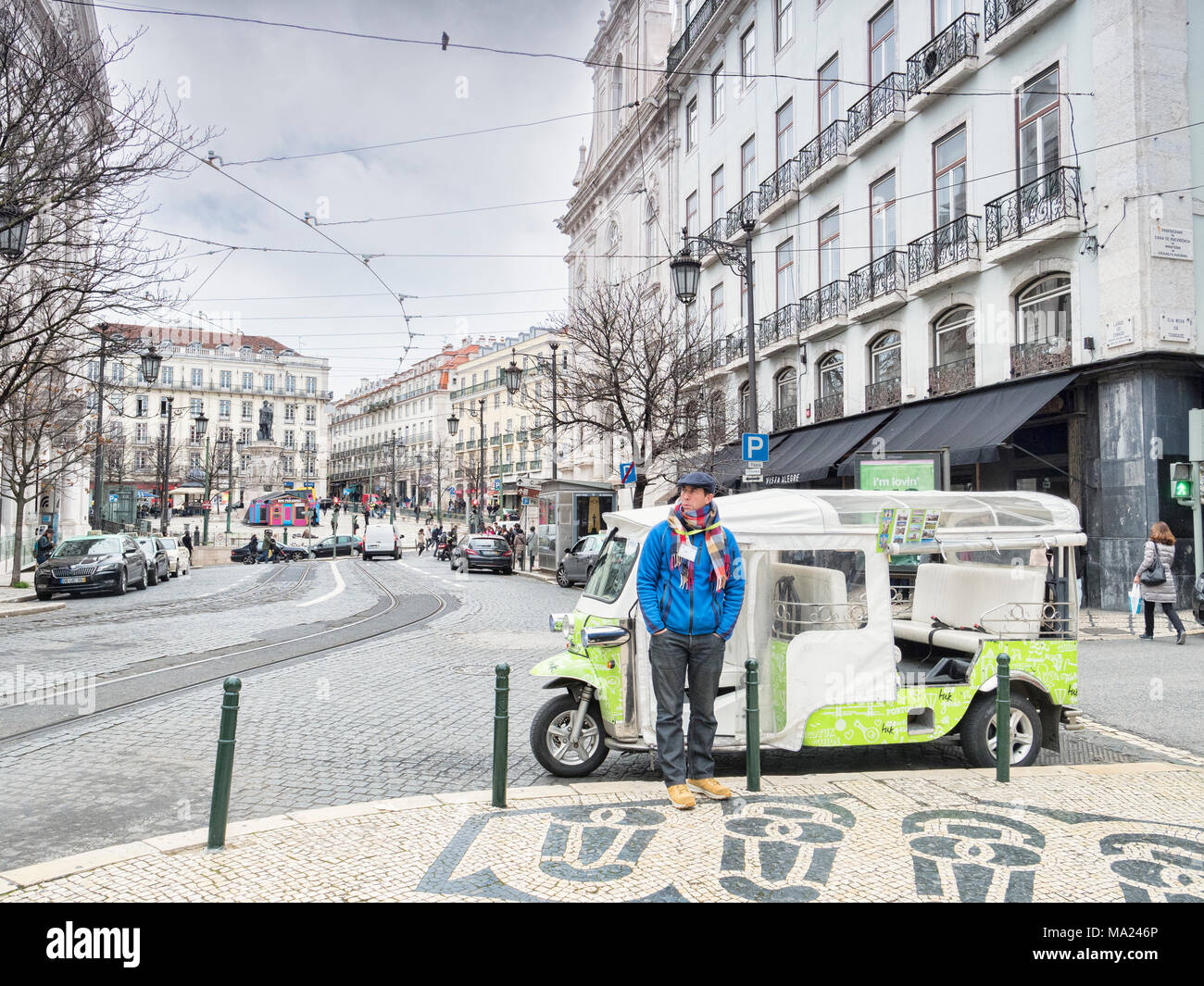 Vom 7. März 2018: Lissabon, Portugal - Tuk Tuk Fahrer wrappede Aufwärmen, Warten auf Business in den Straßen von Lissabon im frühen Frühling. Stockfoto