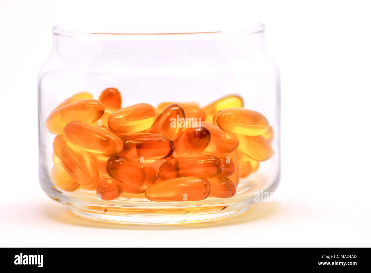Lebertran Omega 3 Vitamin E Kapseln auf weißem Hintergrund in einem Glasfläschchen isoliert Stockfoto