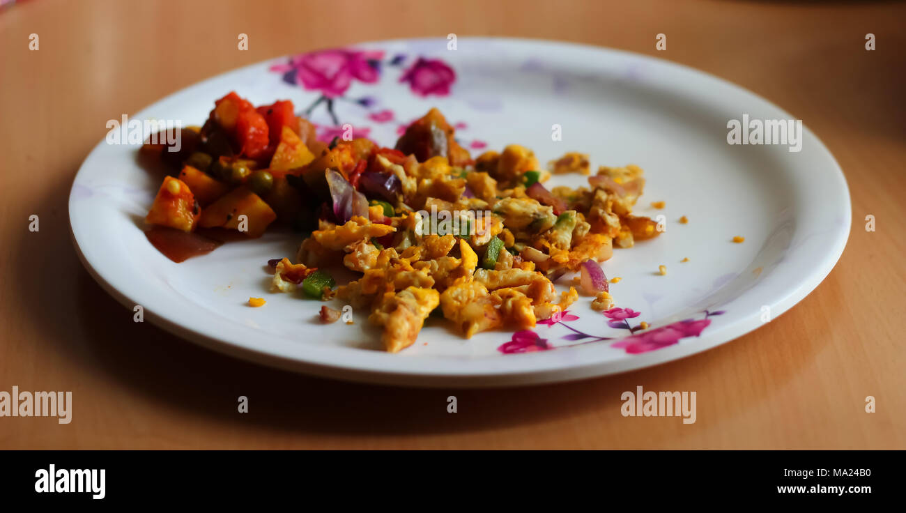 Rührei, Omelette und gemischtes Gemüse auf Teller serviert. Indische hausgemachte Teller. Seitenansicht Stockfoto