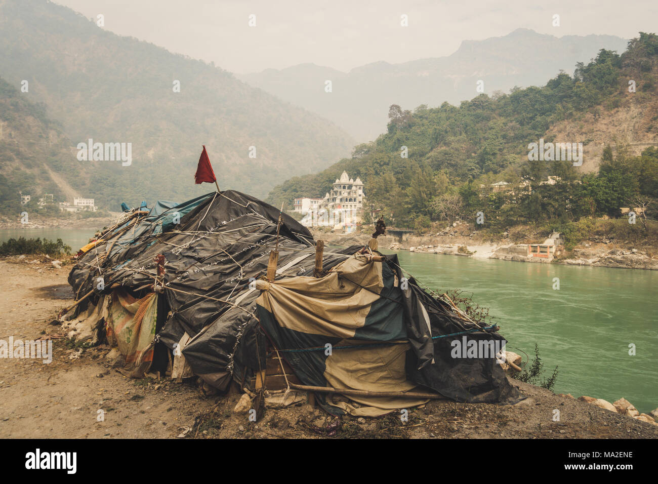 Beggar's Hütte am Fluss Ganges, Rishikesh auf dem Hintergrund einer umfangreichen teuren Tempel. untere Kaste. Die soziale Ungleichheit. Das Problem der Armut und t Stockfoto